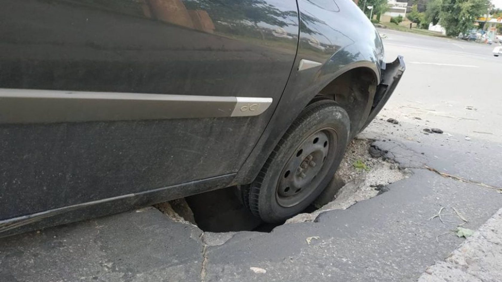 Колесо попало в яму на дороге. Колесо в яме на дороге. Повреждение автомобиля.